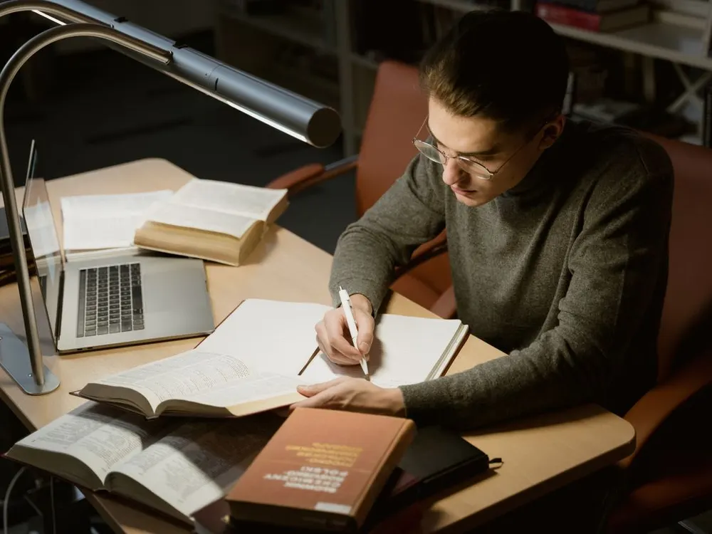 Person studying with books and a laptop